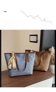 Detail of canvas tote bags in blue and brown with leather handles and decorative scarf
