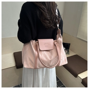 Close-up of pink tote bag with textured finish and embossed fashion logo detail