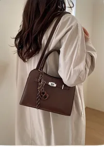 Detail of dark brown lychee leather handbag with silver twist lock and twilly scarf