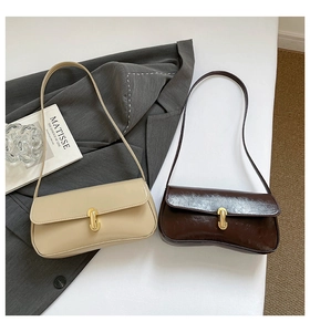 Close-up of beige and coffee baguette bags with elegant gold metal buckles and leather straps