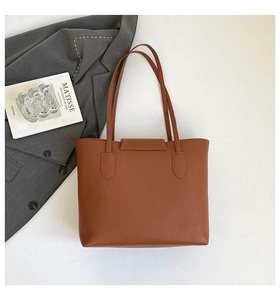 Close-up of caramel leather tote bag with lychee texture and long shoulder straps