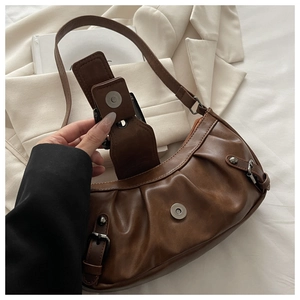 Detail of vintage brown PU leather bag with magnetic buckle and metallic hardware