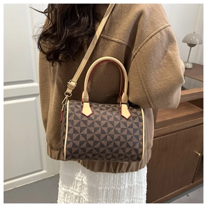 Detail of color-block cylinder Boston bag with geometric pattern and red edge finishing