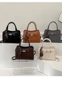 Front view of classic satchel bags in five colors on a white minimalist display stand