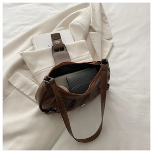 Detailed interior of a vintage brown leather tote bag showing capacity and magnetic clasp