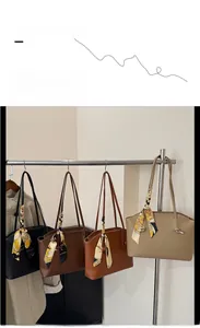 Detailansicht von vier Leder-Shoppern in Schwarz, Braun, Tan und Beige mit Seidenschals