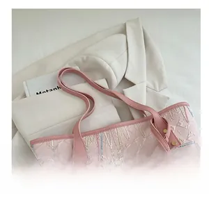 Detail of light pink tote bag set with textured letters and colorful wave embroidery
