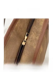 Macro view of smooth gold metal zipper and textured brown canvas on the tote bag