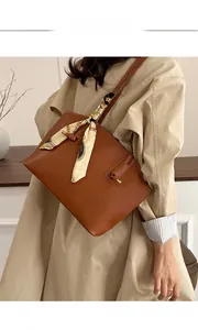 Braune Leder-Tote-Bag mit bedrucktem Seidentuch, getragen zum beigen Trenchcoat