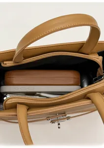 Close-up of tan square handbag interior showing daily storage capacity and silver buckle