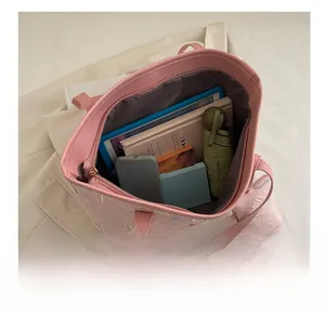 Detailed internal capacity view of pink striped tote bag with matching storage pouch