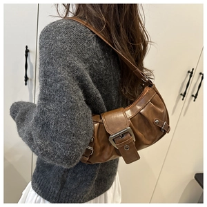 Detail of dark brown vintage shoulder bag with pleated texture and silver buckle strap