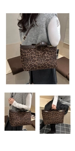 Detail of leopard print tote bag with brown leather trim and golden hardware accents