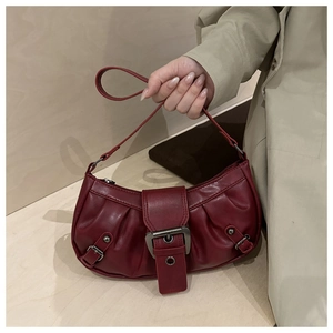 Detail of dark red pleated tote bag featuring a vintage metallic buckle and PU leather texture
