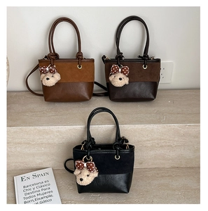 Detailed close-up of mini crossbody bags with suede patchwork and plush bear charms