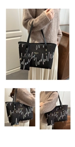 Detailed view of black tote bag featuring heart embroidery and matching charm pouch
