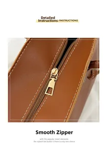 Makrodetail des goldenen Metallreißverschlusses und der weißen Naht auf brauner Ledertasche