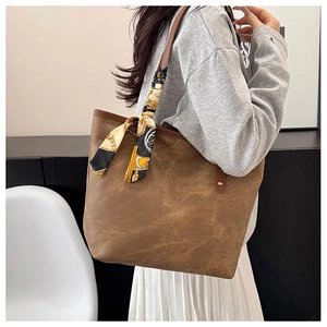 Brown faux suede tote bag with printed silk scarf and metallic rivets on shoulder strap
