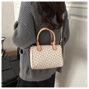 Detail view of a Boston style bag with geometric patterns and red edge finish on straps