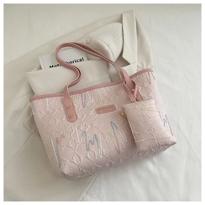 Detailed shot of pink quilted tote bag with colorful wave embroidery and matching pouch