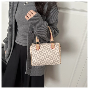 Detail of Boston handbag showing geometric patterns and leather handles on a model