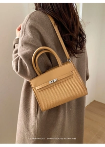 Minimalist camel leather and woven patchwork handbag worn by model from a side-back angle