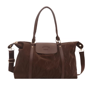 Large dark brown travel tote bag with leather handles and textured fabric finish