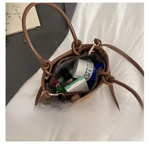 Top view of deep brown bucket bag showing internal capacity with cosmetics and zip closure