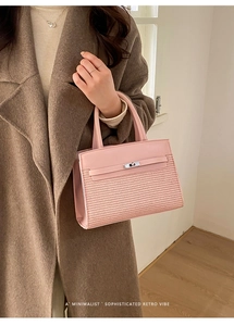 Detail of pink crossbody bag with woven texture, smooth leather, and silver metal twist lock