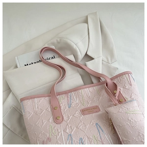 Detail of pink quilted tote bag with wave embroidery and mini pouch attachment