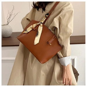 Braune Leder-Tote Bag mit dekorativem Seidenschal am Griff und beigem Trenchcoat-Look