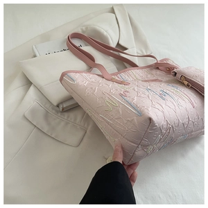 Detail of pink tote bag with geometric embossing and colorful wave embroidery