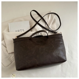 Detail shot of vintage dark brown tote bag with textured faux leather and shoulder strap