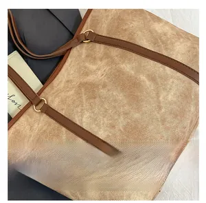 Detail of vintage canvas tote bag with brown leather handle and gold metal ring fastener