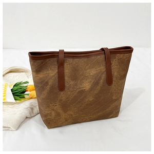 Detail of caramel brown retro tote bag with premium matte texture and leather handles
