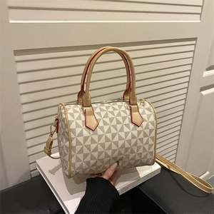 Minimalist geometric patterned cylinder bag with leather handles and long shoulder strap