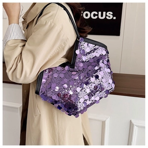 Side view of a medium purple sequin tote bag with black leather straps on a model