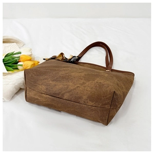 Brown textured tote bag with silk scarf accent styled with tulips on white fabric