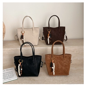Row of four vintage-style matte leather bucket bags in black, brown, and beige tones