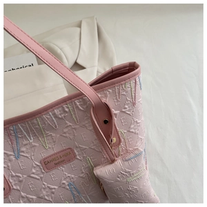 Detail of pink quilted tote bag showing textured embossing and premium gold hardware accents