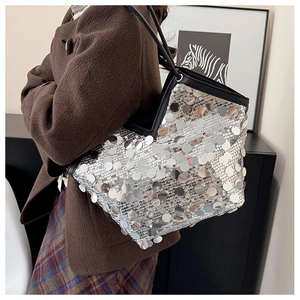 Detailed close-up of large capacity silver sequin tote bag with black leather straps