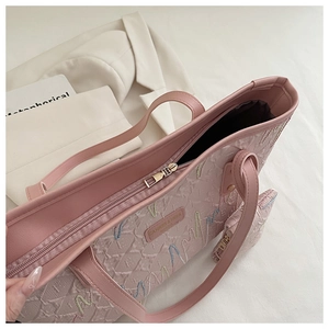 Detail of pink striped tote bag showing textured fabric and metallic zipper closure