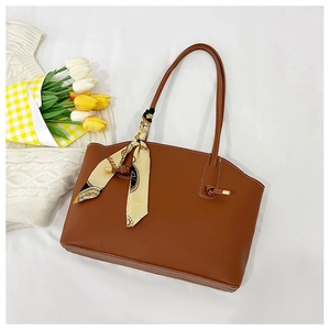 Close-up of brown leather tote bag with a decorative silk scarf and tulip accents