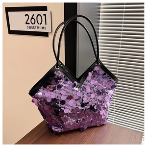 Macro detail of purple sequin tote bag showing reflective texture and black leather handle