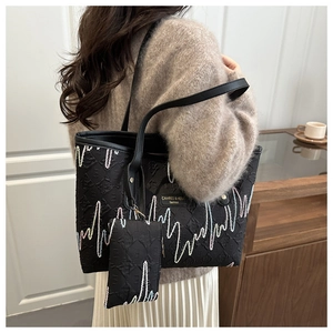 Detail of black jacquard tote bag with E-pattern and colorful zigzag stitching detail