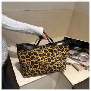 Detailed shot of leopard rose tote bag with premium metal plate and faux leather handles