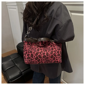 Detail of leopard rose print tote bag with brown leather trim and silver hardware