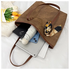 Interior view of brown tote bag showing capacity for tablet, umbrella, and notebook