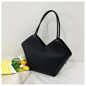 Detail of minimalist black tote bag featuring a unique V-shaped opening and long straps