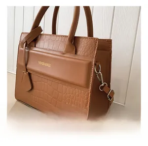 Détail du sac à main marron foncé à motif pierre avec crochet argenté et logo doré